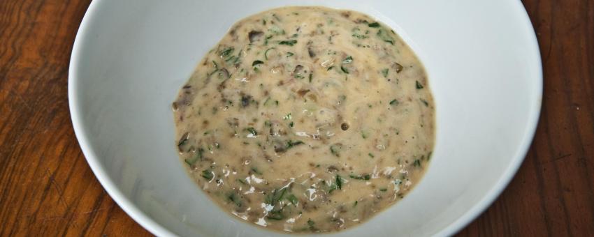 A bowl of freshly prepared sauce remoulade. Essential ingredients: egg yolk, vinegar, oil, salt, ground pepper, capers, anchovy, freshly cut tarragon and chervil, chopped gherkin