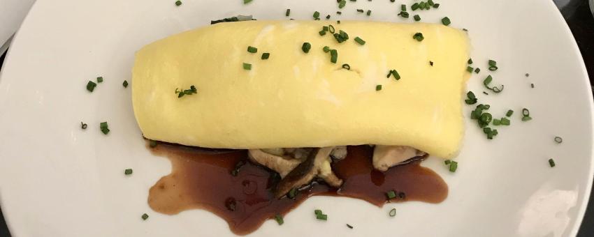 Omelet with herbs and mushrooms. A perfectly cooked omelet or omelette has no browning.