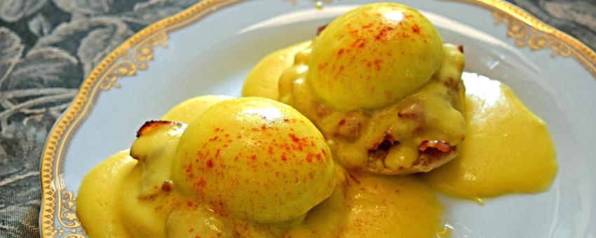 Hollandaise sauce as part of Eggs Benedict with bacon, sprinkled with paprika