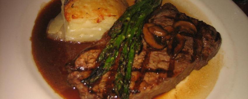 Grilled Creekstone Farms New York Steak with Mushroom Madeira Sauce, Scalloped Potatoes and Grilled Asparagus.