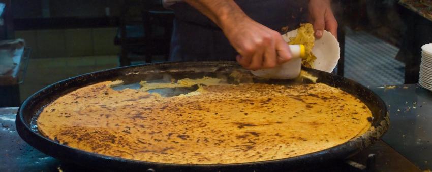 Socca, just coming out of the oven and served hot, in the old town of Nice (Vieux-Nice), on the French Riviera (Alpes-Maritimes, France).