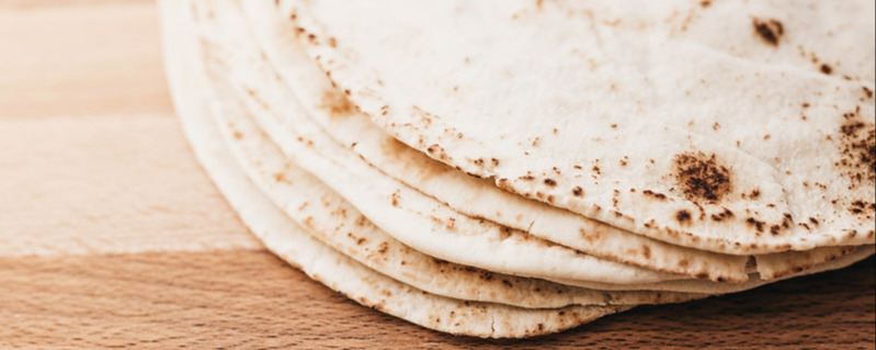 Stack of pita bread on wooden board