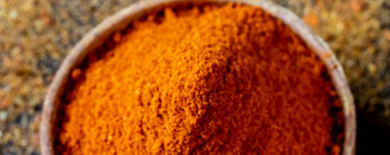 Colorful spices in wooden bowls on a dark background