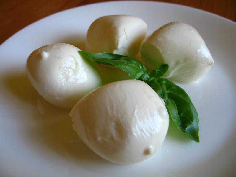 Bocconcini (in this case made from cow's milk), with a sprig of basil.